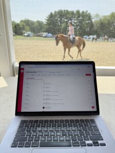 Equestrian event organizer using Pegasus horse show system on a laptop during a horse show