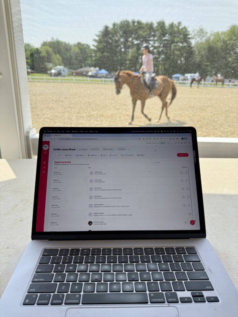 Equestrian event organizer using Pegasus horse show system on a laptop during a horse show